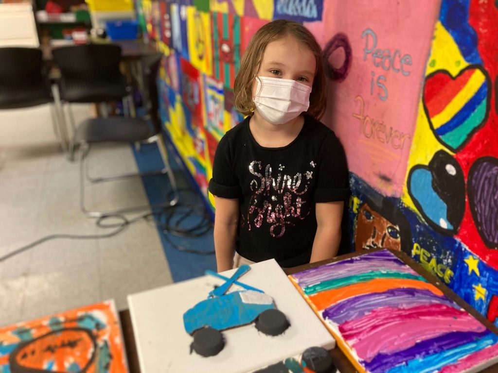 Young girl surrounded by arts and crafts