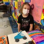 Young girl surrounded by arts and crafts