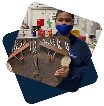 Student holding up his art project