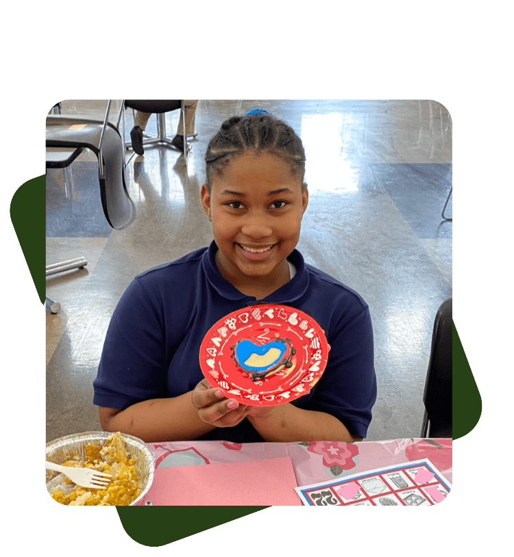 Students holding valentines day cookie art