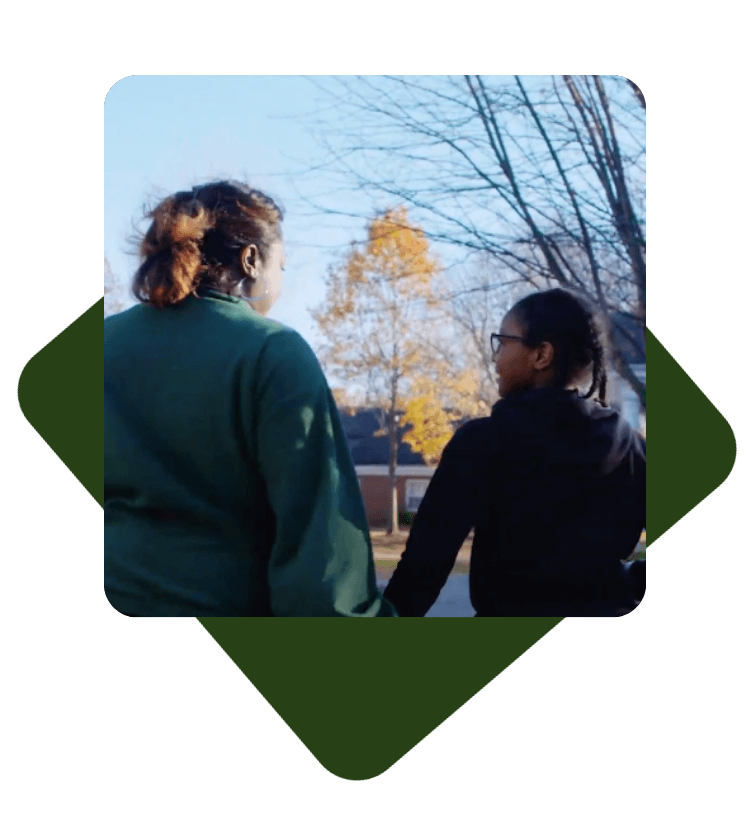 Student and mother holding hands from behind